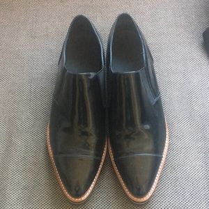 Vince Pair of black vinyl sneakers.